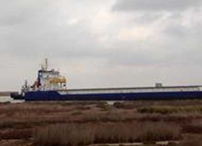 Un barco de grandes dimensiones queda varado en la orilla del río Guadalquivir a su paso por Trebujena